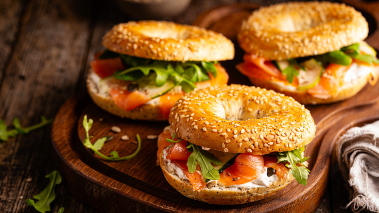 Three bagel sandwiches on a cutting board
