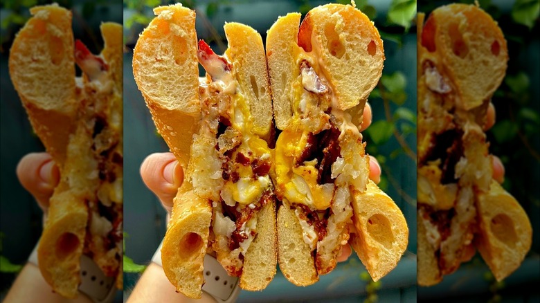 Hand holding a sandwich cut in half