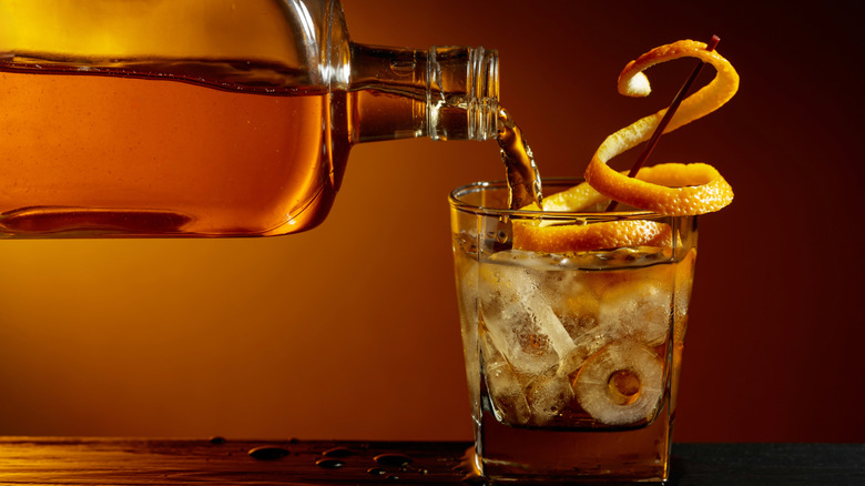 Pouring an old fashioned cocktail with bourbon