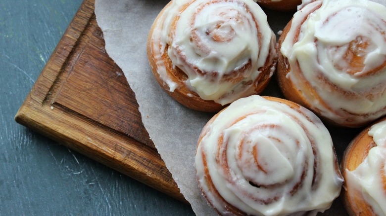 Cinnamon rolls sit wooden platter