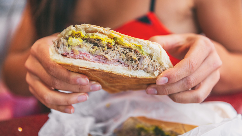 holding Cuban sandwich 