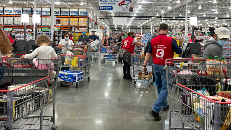 Several Costco shoppers in aisles
