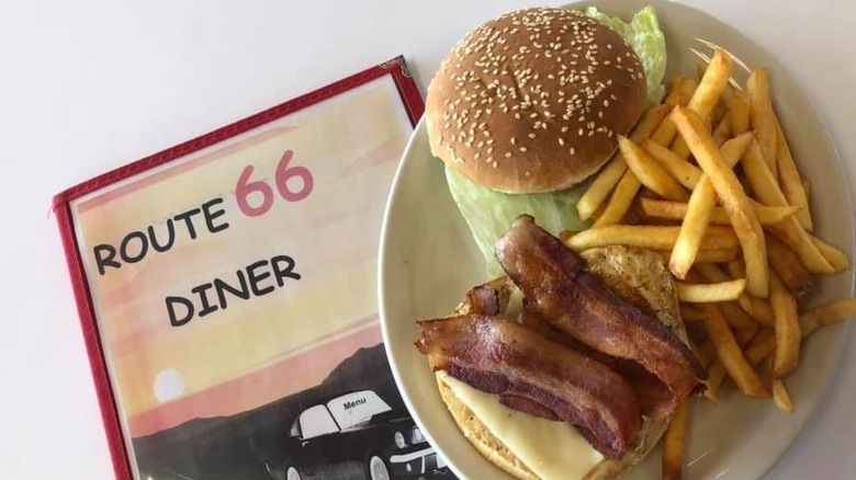 Plate of burger and fries next to menu for Route 66 Diner