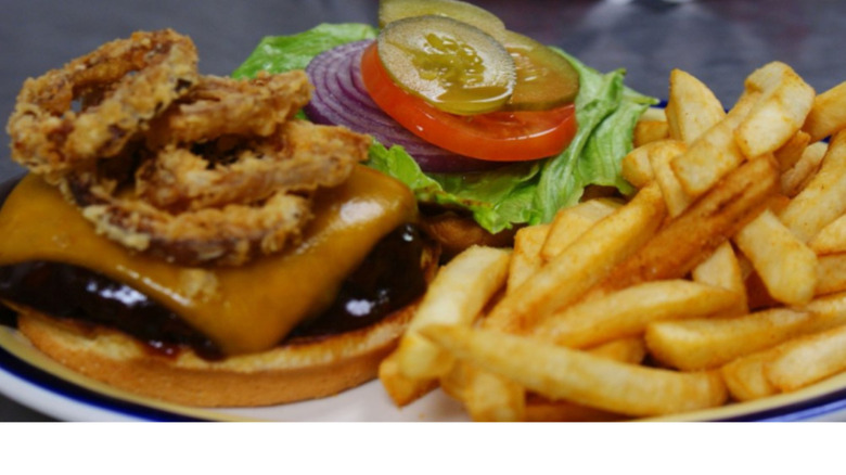 Open-face onion ring cheeseburger with fries