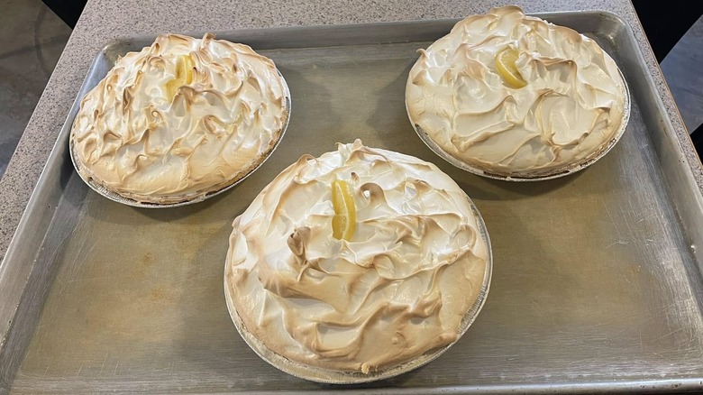 Three lemon meringue pies on tray