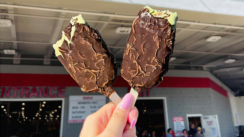hand holding two Dubai chocolate bars outside Costco