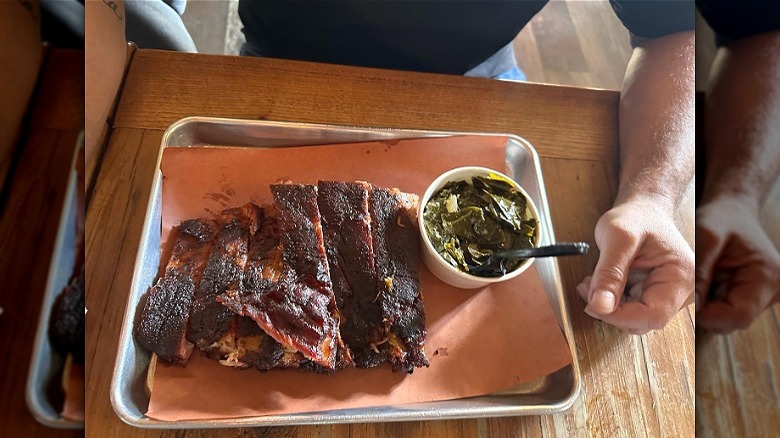Barbecue ribs on tray with collard greens