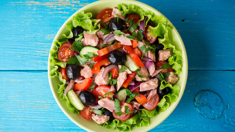 Fresh salad with tuna on blue table