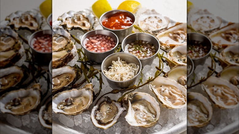 shucked oysters on ice with condiments