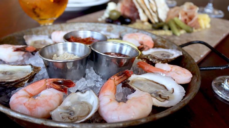 shrimp and oysters on a chilled platter with cocktail sauce