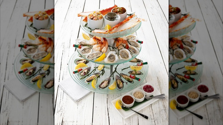 seafood tower with assorted seafood and sauces on the side