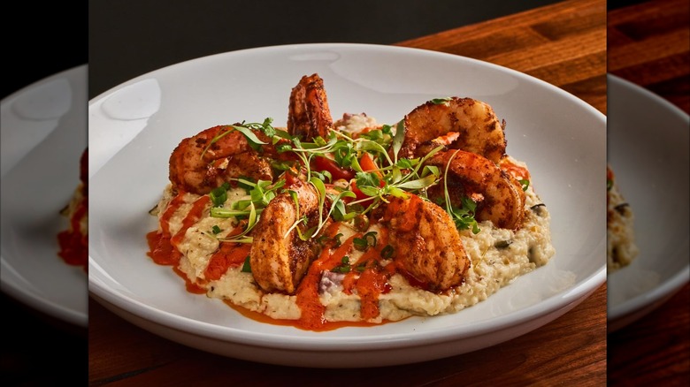 shrimp and grits plated with sauce and microgreens