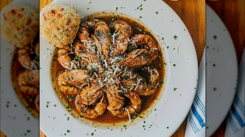 a plate of prepared shrimp with a cheddar biscuit