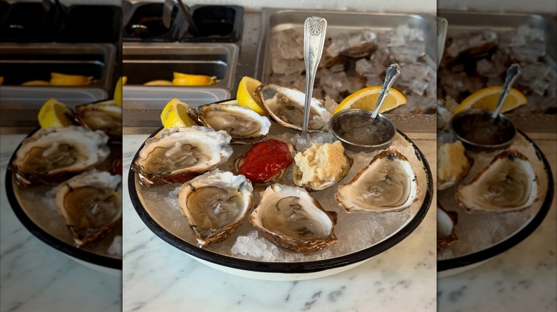 shucked oysters on ice with lemon, horseradish, and cocktail sauce