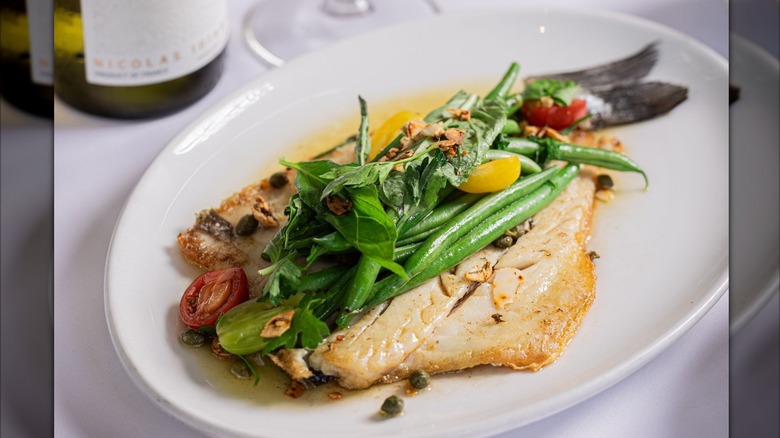 Grilled fish plated with vegetables