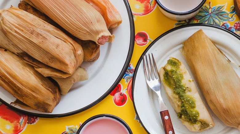 a plate of tamales on a colorful yellow background