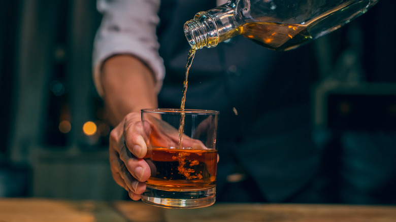 Man pouring whiskey into a glass