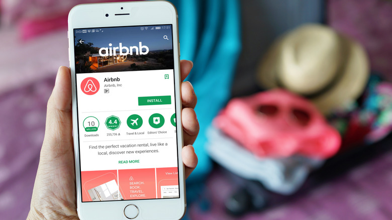 Person holding phone showing Airbnb app