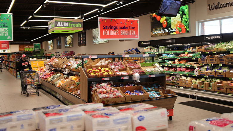 Person walking into Aldi with grocery cart