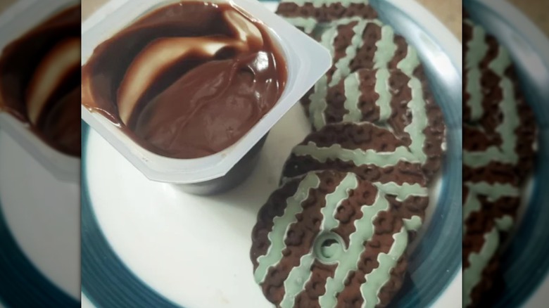 A close up of a plate with mint layer cookies and chocolate pudding 