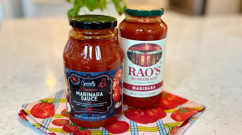 Two jars of marinara sauce sitting on a napkin on the table