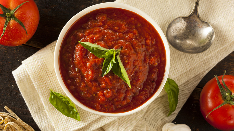 Marinara sauce in bowl with herbs
