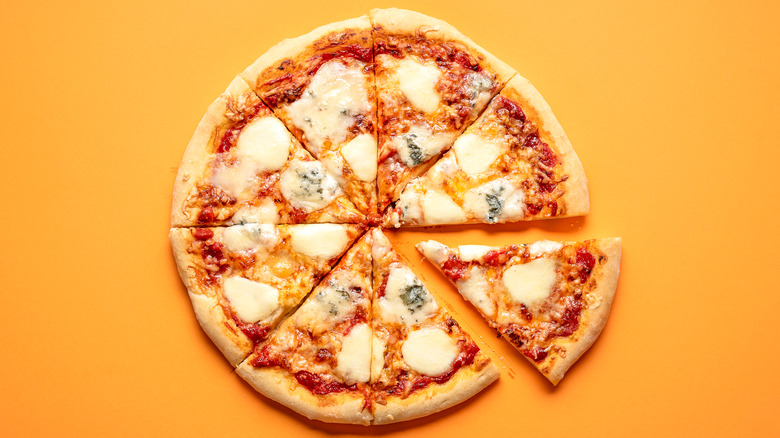 Close up of a sliced pizza with tomato sauce and cheese