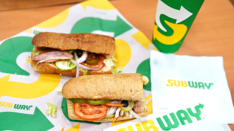 Subway sandwiches on packaging next to cup