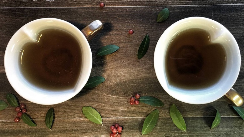 Yaupon berries and leaves next to tea in cups