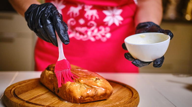 Person brushing butter on bread