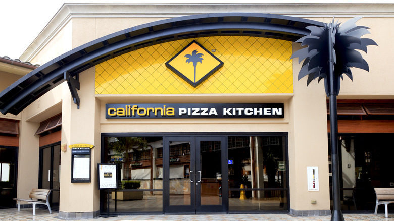 California Pizza Kitchen building next to black palm tree