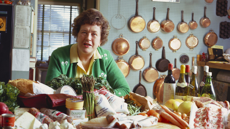 Julia Child in her kitchen with food, wine, and pans