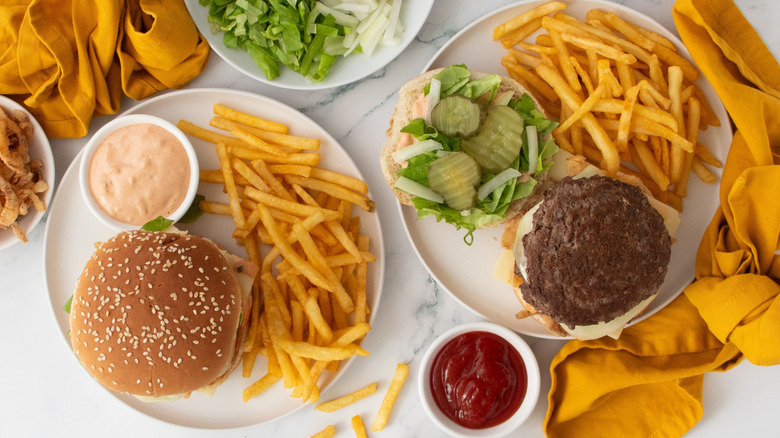 McDonald's Big Arch burgers on plates with fries and sauces