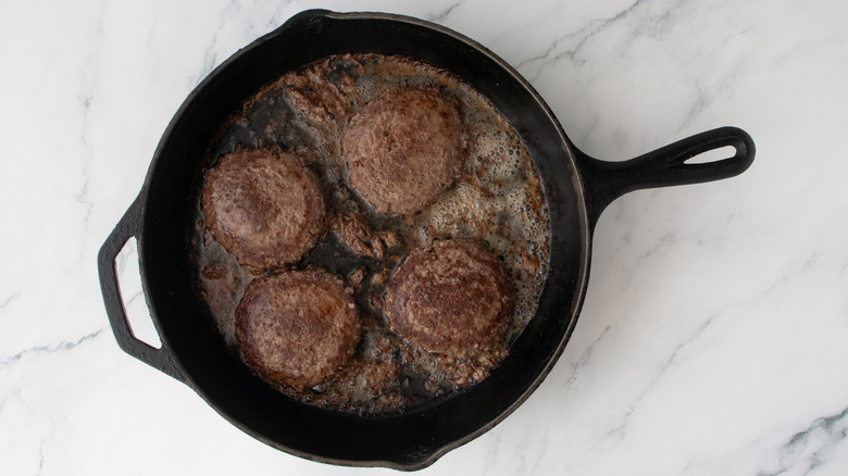 Cooked burgers in skillet