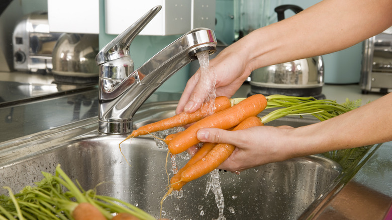 Washing carrots at the sink