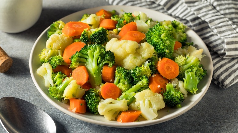 Plate of cooked broccoli, cauliflower, and carrots