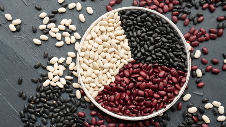 Pinto, black, and kidney beans on dark wood table