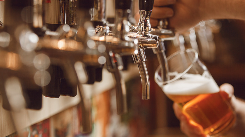 A bartender pouring beer from a tap