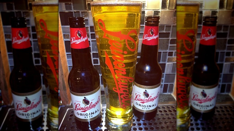 Two bottles of Leinenkugel's beer with glass in between