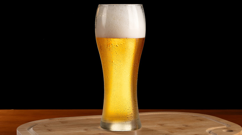 Glass of pilsner against a black background