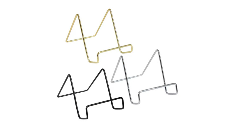Three small metal easels in black, silver, and gold