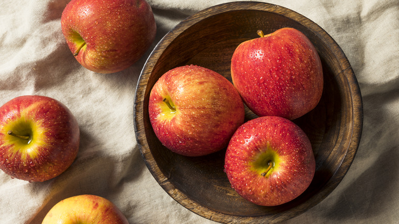 Wooden bowl with Envy apples resting inside
