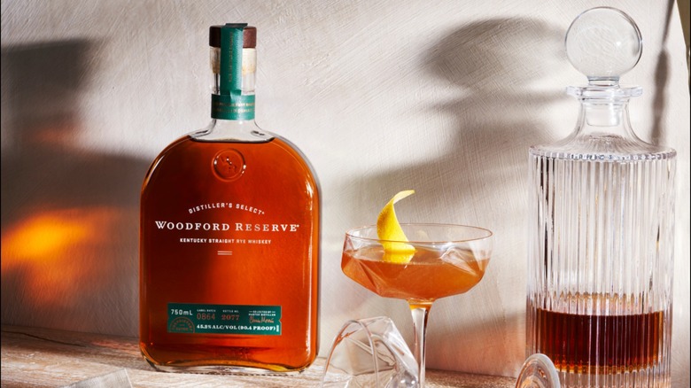 Bottle of Woodford Reserve Rye Whiskey with cocktail and decanter