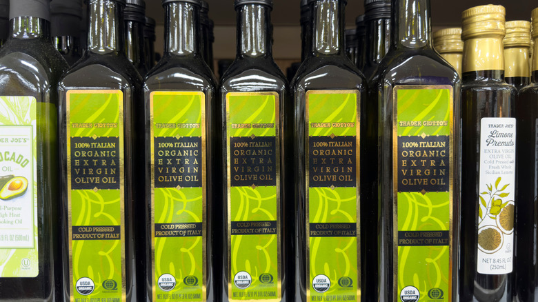 Several bottles of Trader Giotto's extra-virgin olive oil on a supermarket shelf