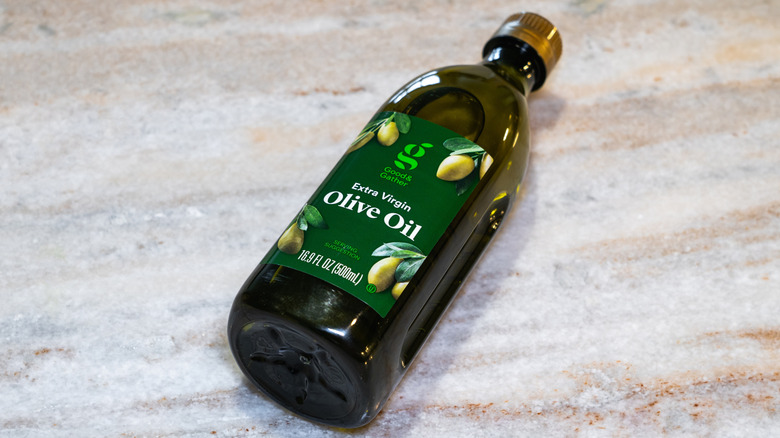 Bottle of Good & Gather Extra-Virgin Olive Oil lays on a marble background
