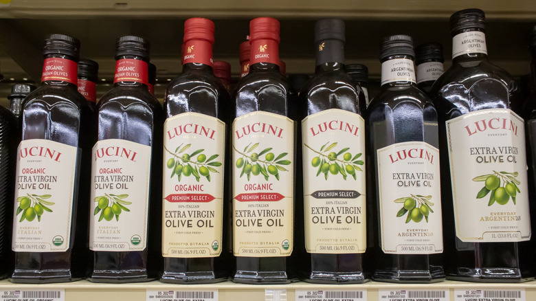 Bottles of different types of Lucini olive oil on a grocery shelf