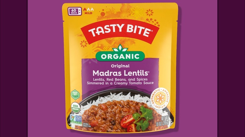 A packet of Tasty Bite Madras Lentils on a purple background