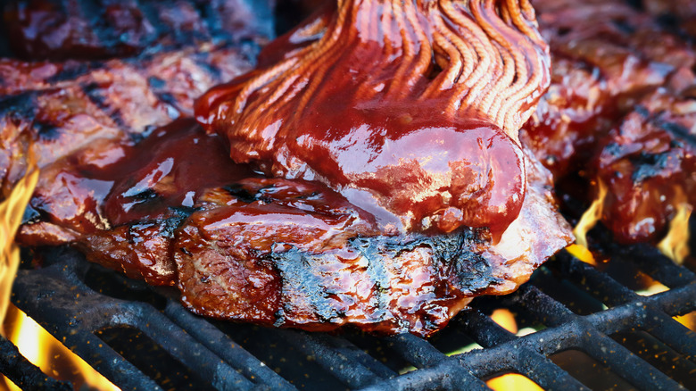 Adding barbecue sauce on the grill