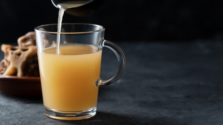 bone broth poured in cup beef bones 