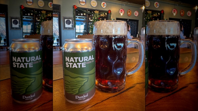 A can of Natural State Beer Company's Dunkel Dark Lager alongside a pint of beer